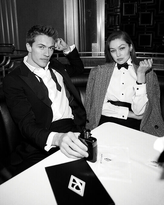 Black and white of male and female model in tuxedos looking straight ahead
